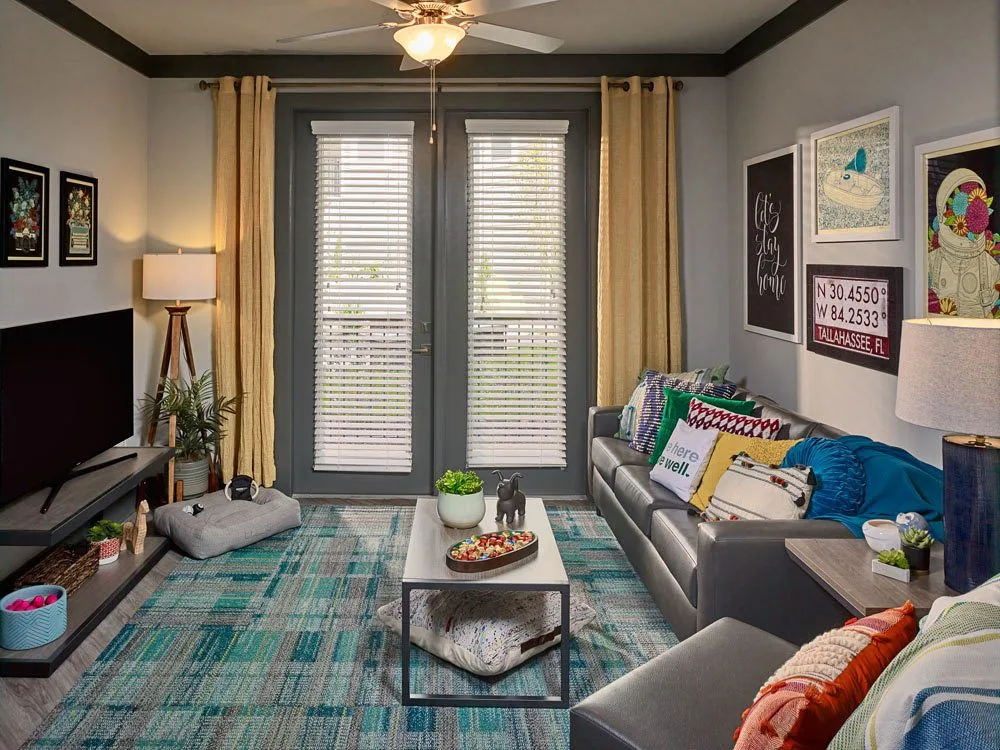 Reference photo of a 4x4 pod living room with sofa, art, and study area