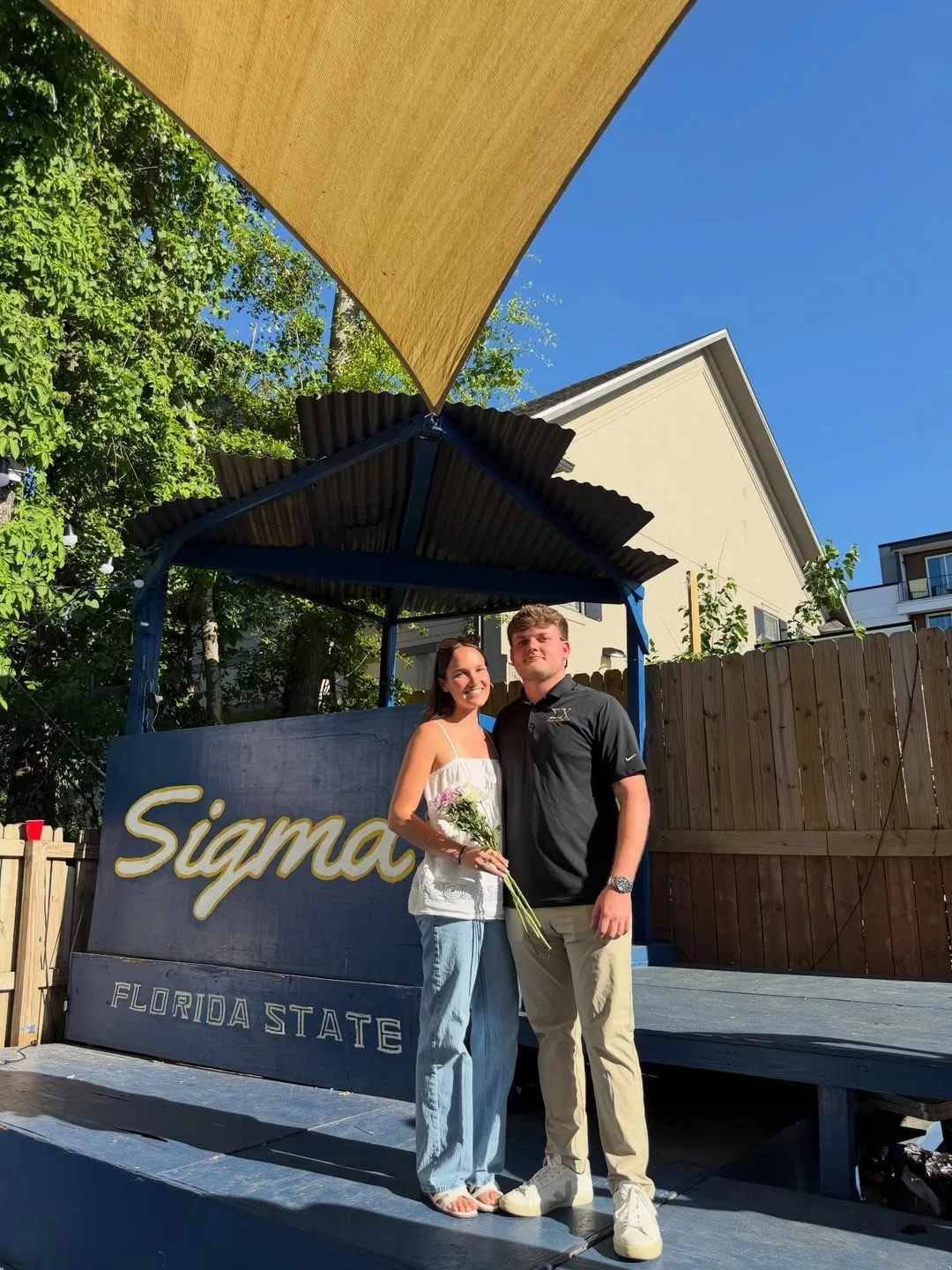 Ella Whittington, 2026 Derby Days Sweetheart, holding flowers in front of the Sigma Chi Florida State sign